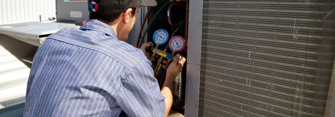 HVAC technician servicing a condenser unit in Vashon